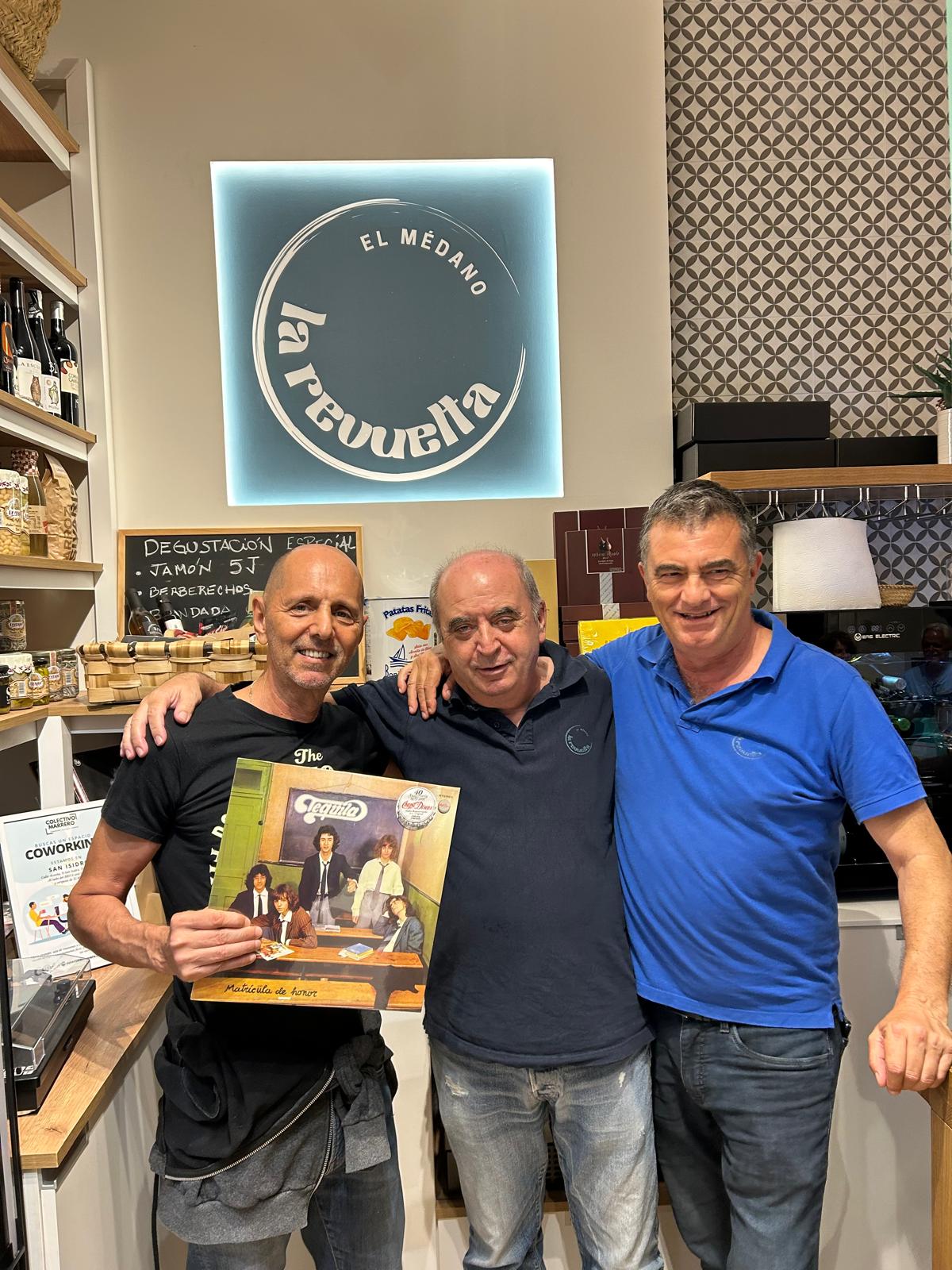 Equipo de La Revuelta con un vinilo bajo el rótulo de la tienda