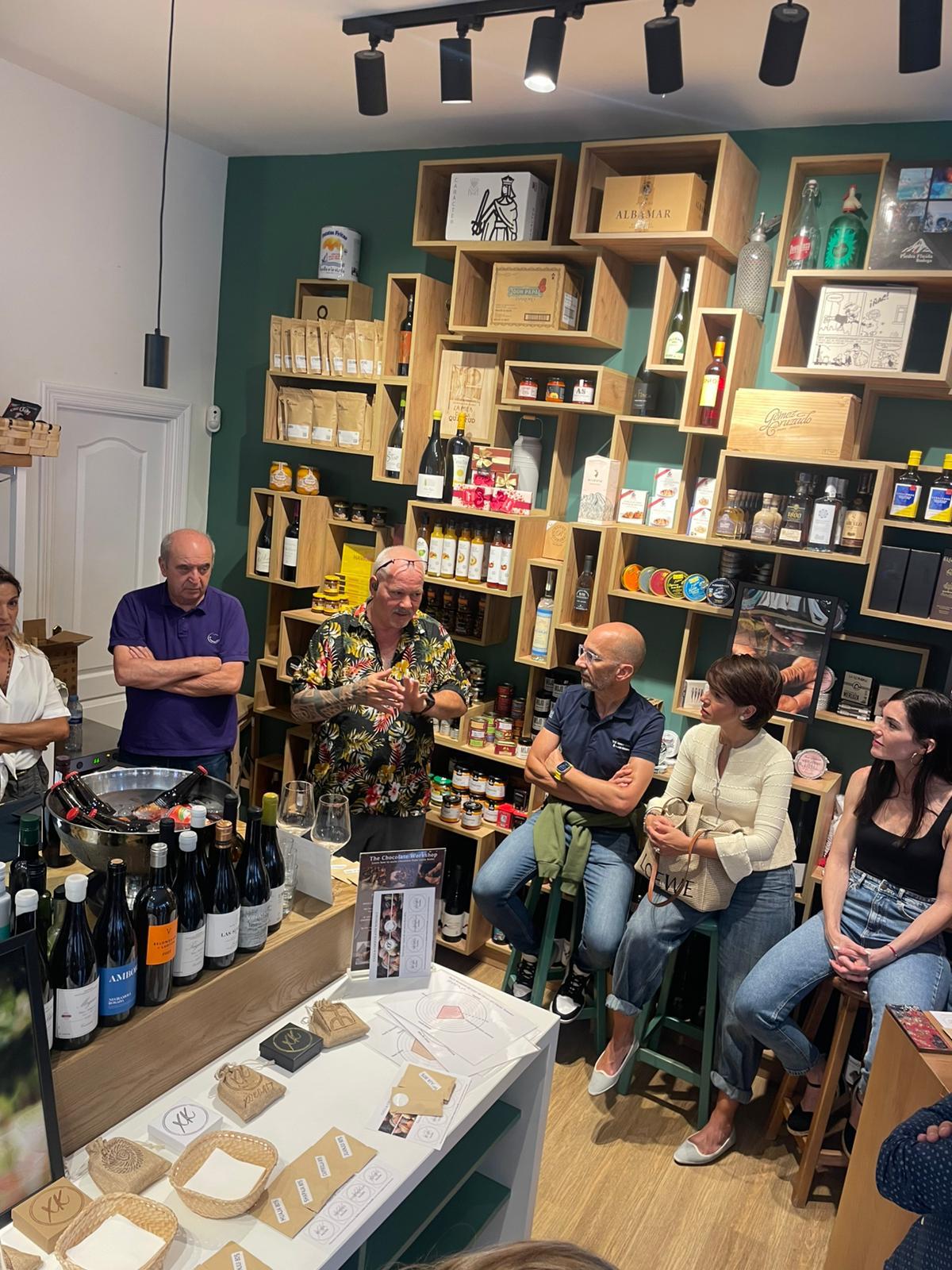 Charla con público entre estanterías de vinos y conservas